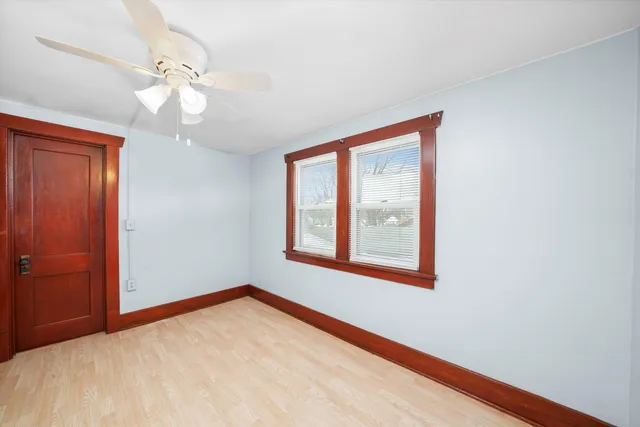 an empty room with windows and fan