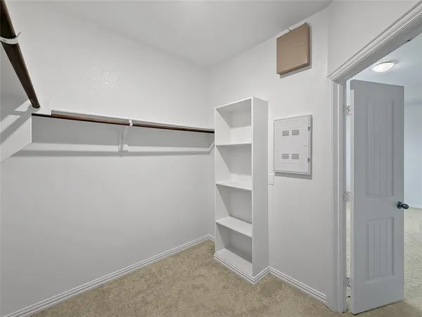 a white toilet sitting next to a white wall