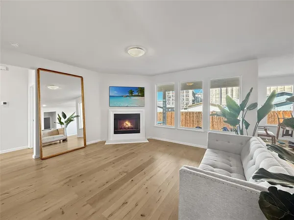 a view of a livingroom with a fireplace wooden floor and window