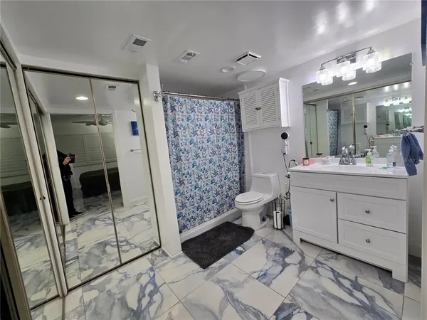a bathroom with a sink mirror and toilet