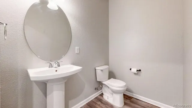 a bathroom with a toilet a sink and a mirror