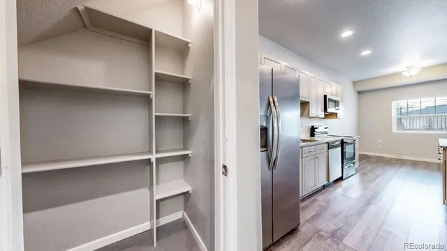 a view of a kitchen with refrigerator and wooden floor