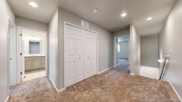 a view of a hallway with closet and bathroom
