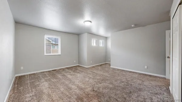 an empty room with windows and closet
