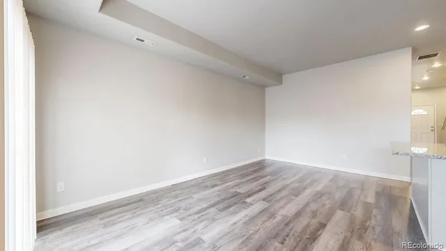 a view of an empty room with wooden floor