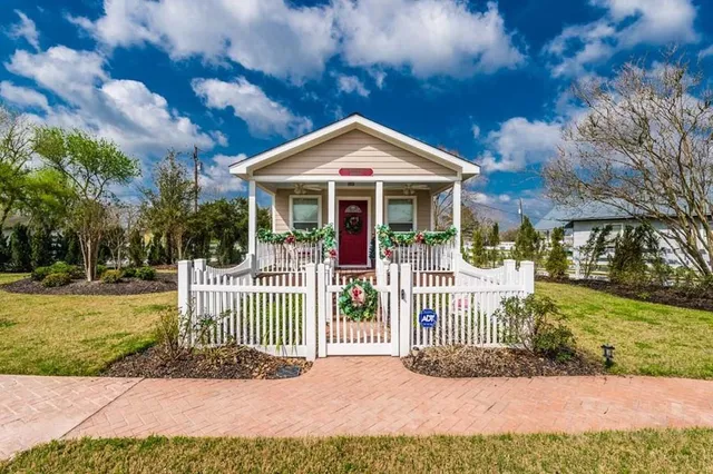 a view of a house with a small yard and fence