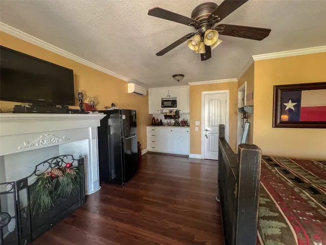 a view of a livingroom with furniture a flat screen tv wooden floor and a ceiling fan