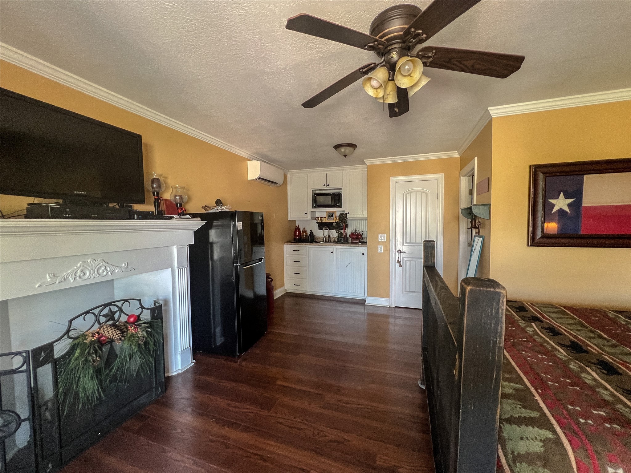 9500 Mayfield Avenue, Unit C Shiro, TX 77873 - Photo 2 of 12 a view of a livingroom with furniture a flat screen tv wooden floor and a ceiling fan
