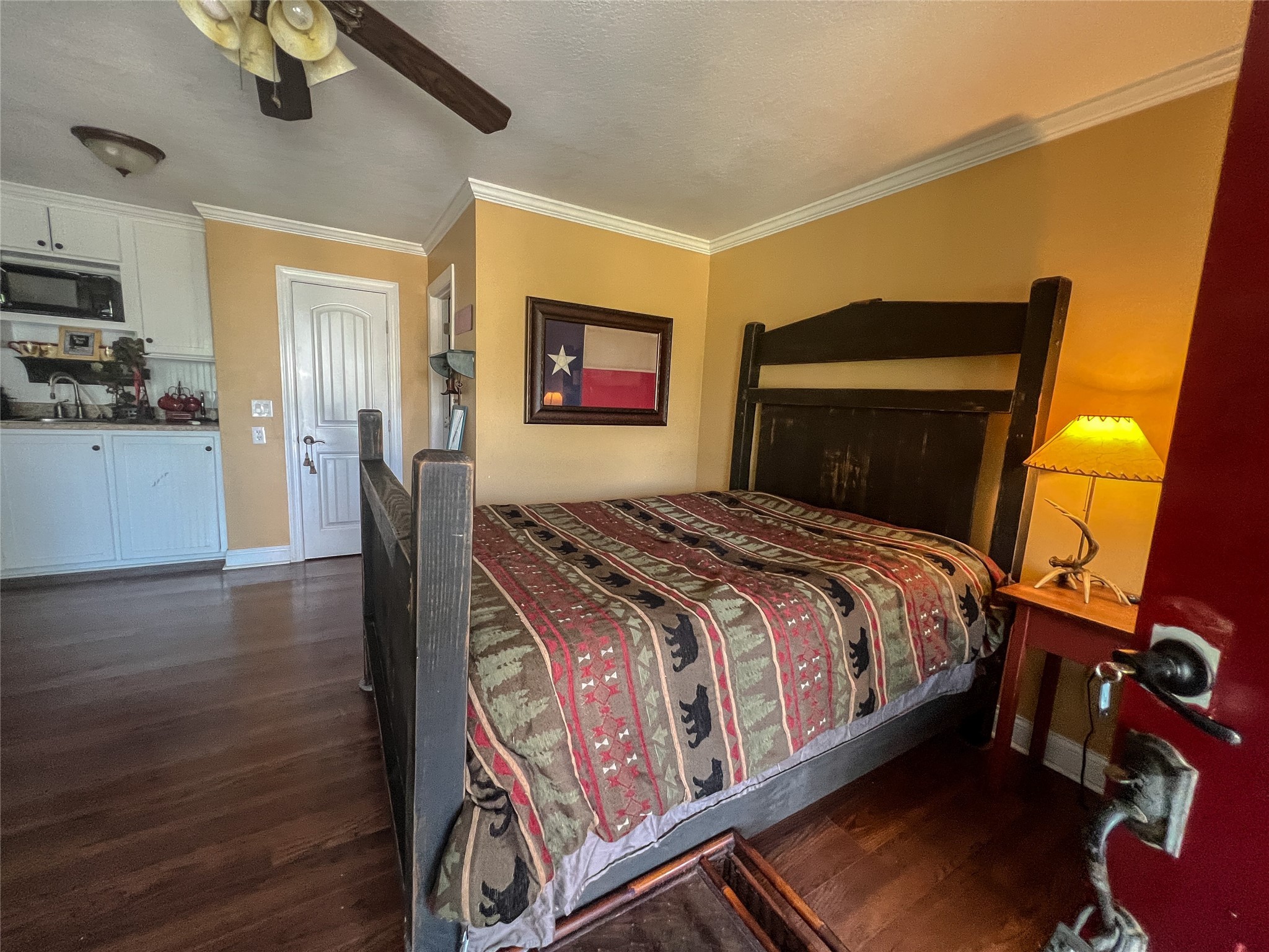 9500 Mayfield Avenue, Unit C Shiro, TX 77873 - Photo 3 of 12 a bedroom with a bed and wooden floor