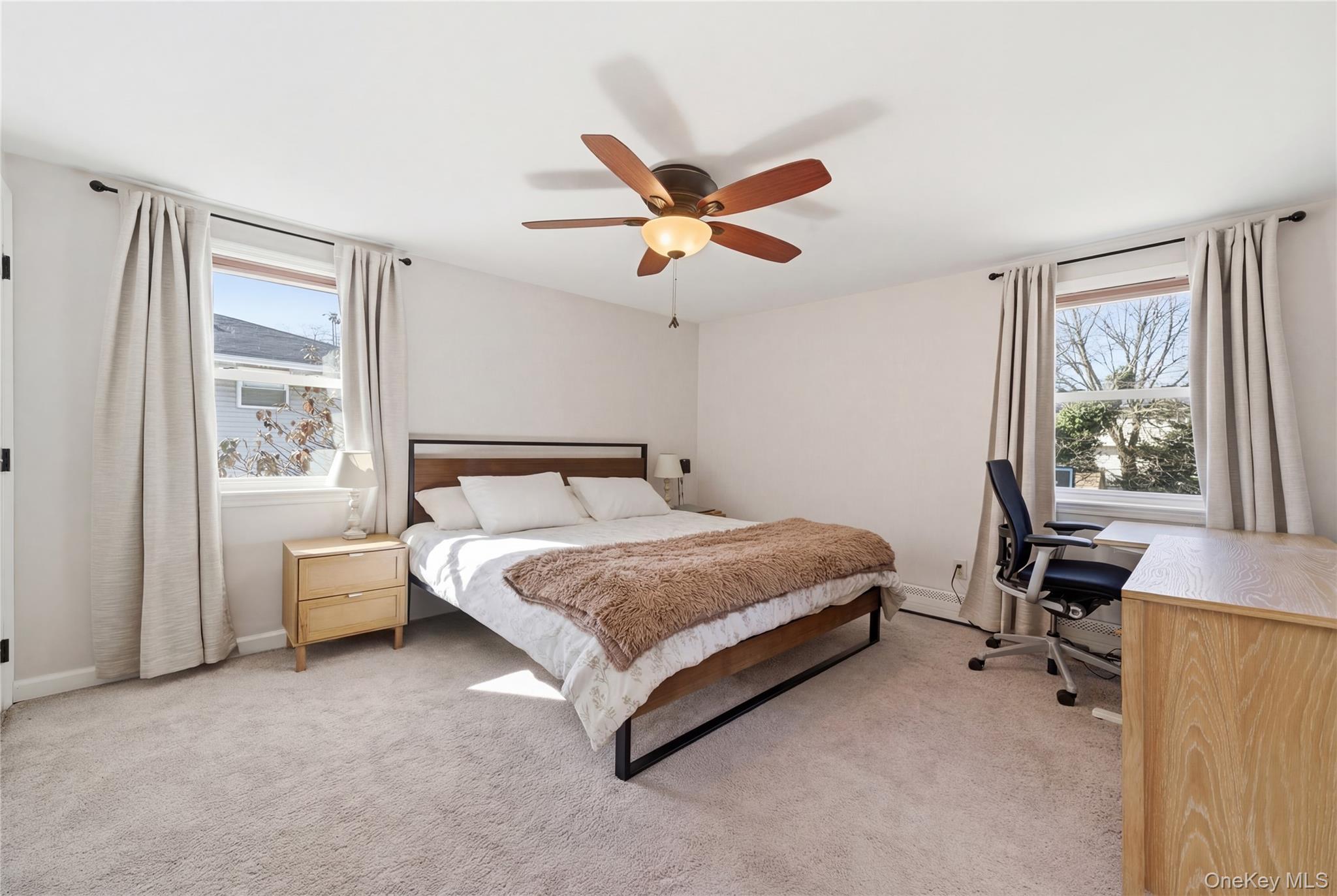 214 Ralph Avenue Babylon, NY 11702 - Photo 11 of 33 a spacious bedroom with a bed and a table in it