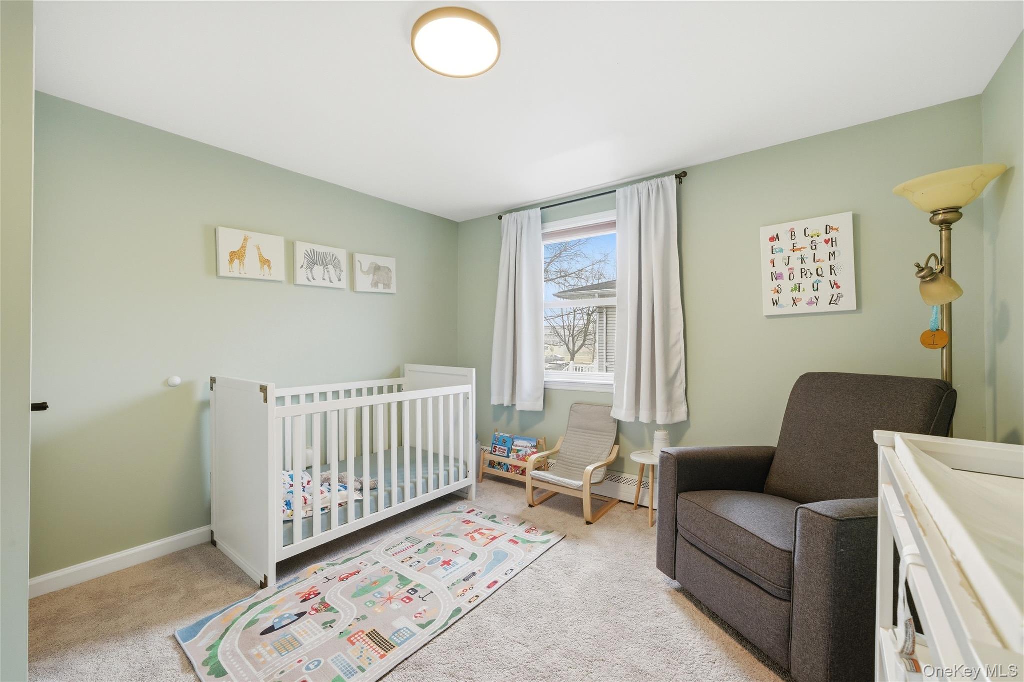 214 Ralph Avenue Babylon, NY 11702 - Photo 13 of 33 a living room with furniture and a baby crib