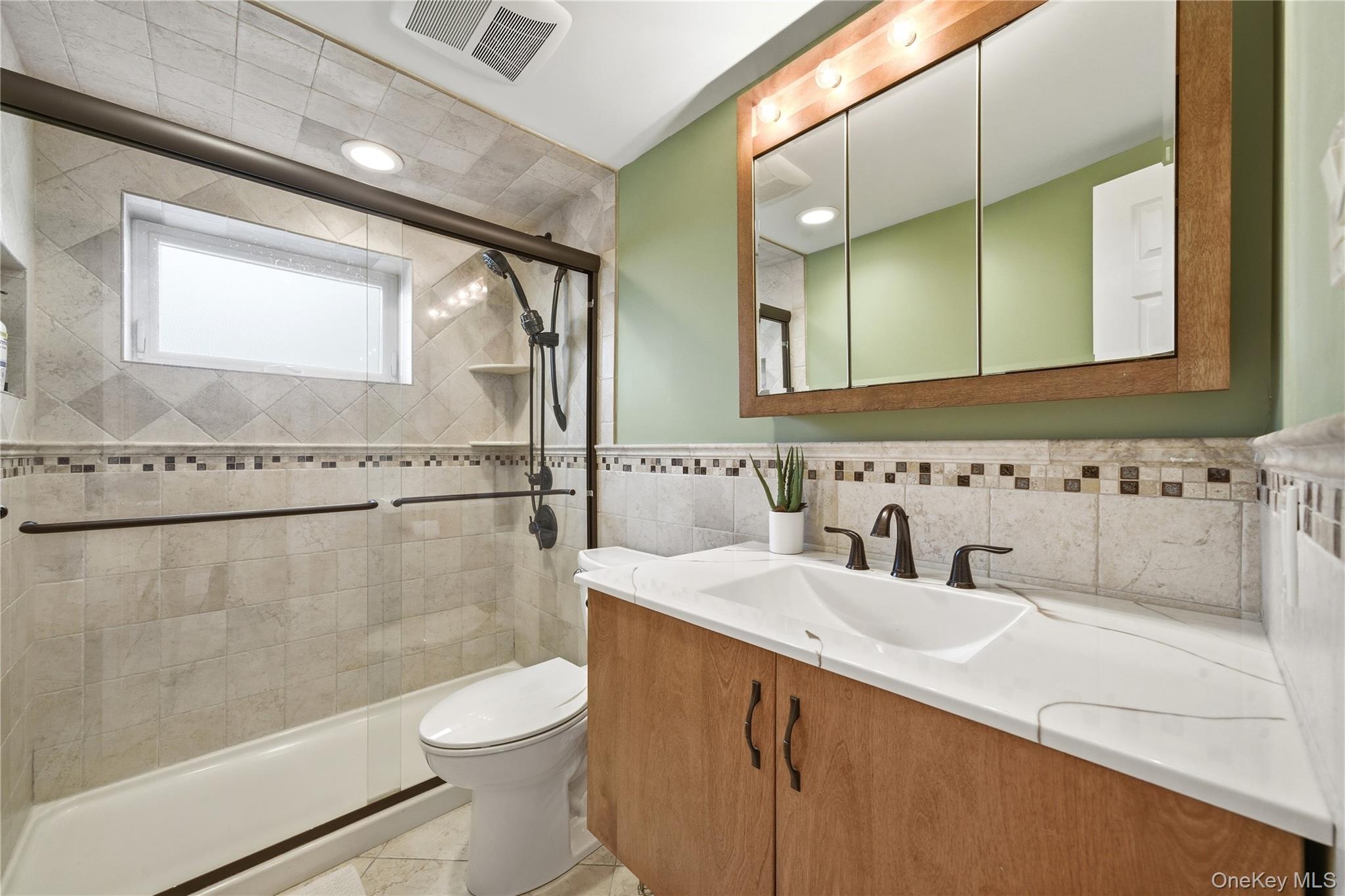 214 Ralph Avenue Babylon, NY 11702 - Photo 21 of 33 a bathroom with a sink a toilet and a mirror