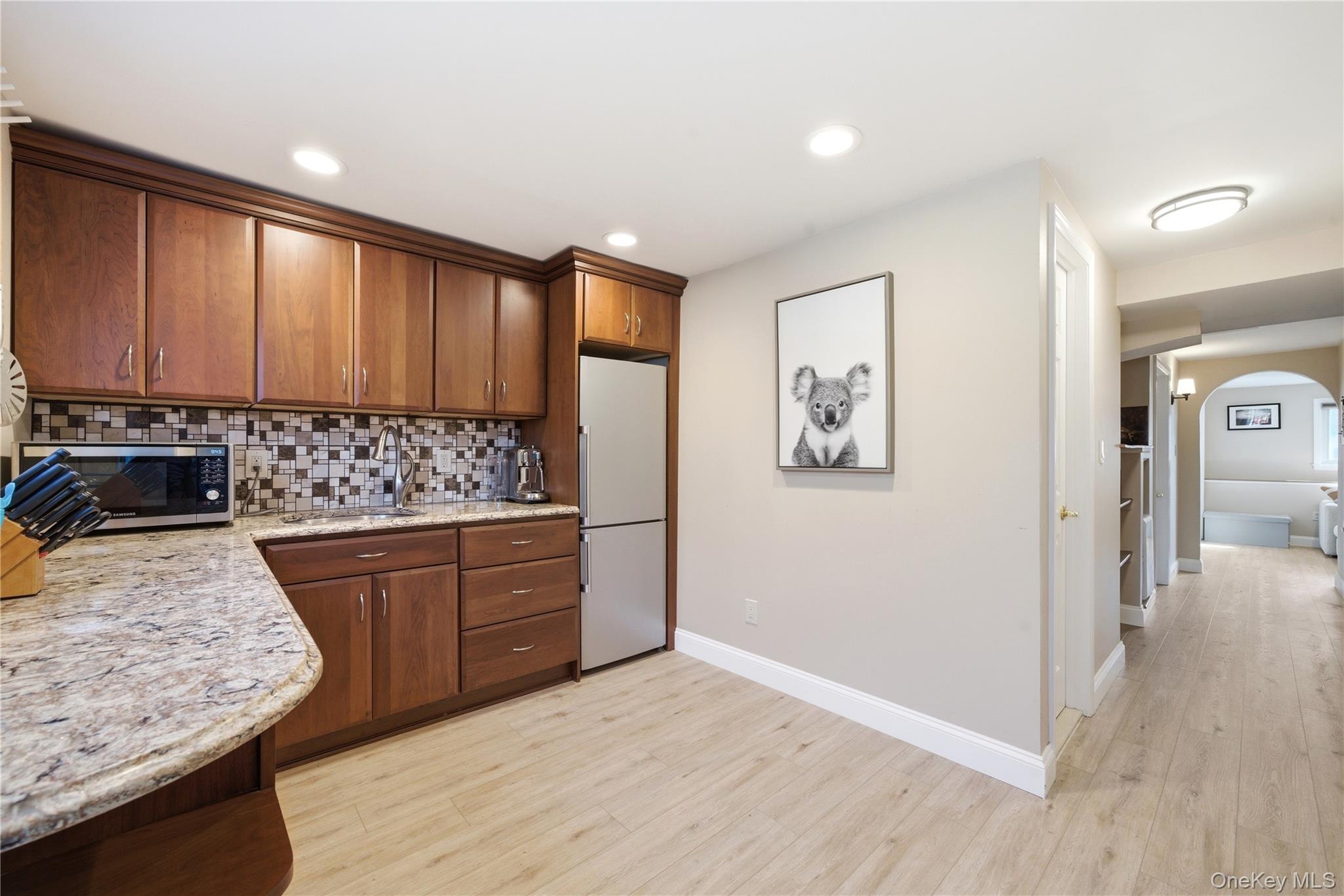 214 Ralph Avenue Babylon, NY 11702 - Photo 23 of 33 a kitchen with stainless steel appliances granite countertop a stove a sink and a refrigerator