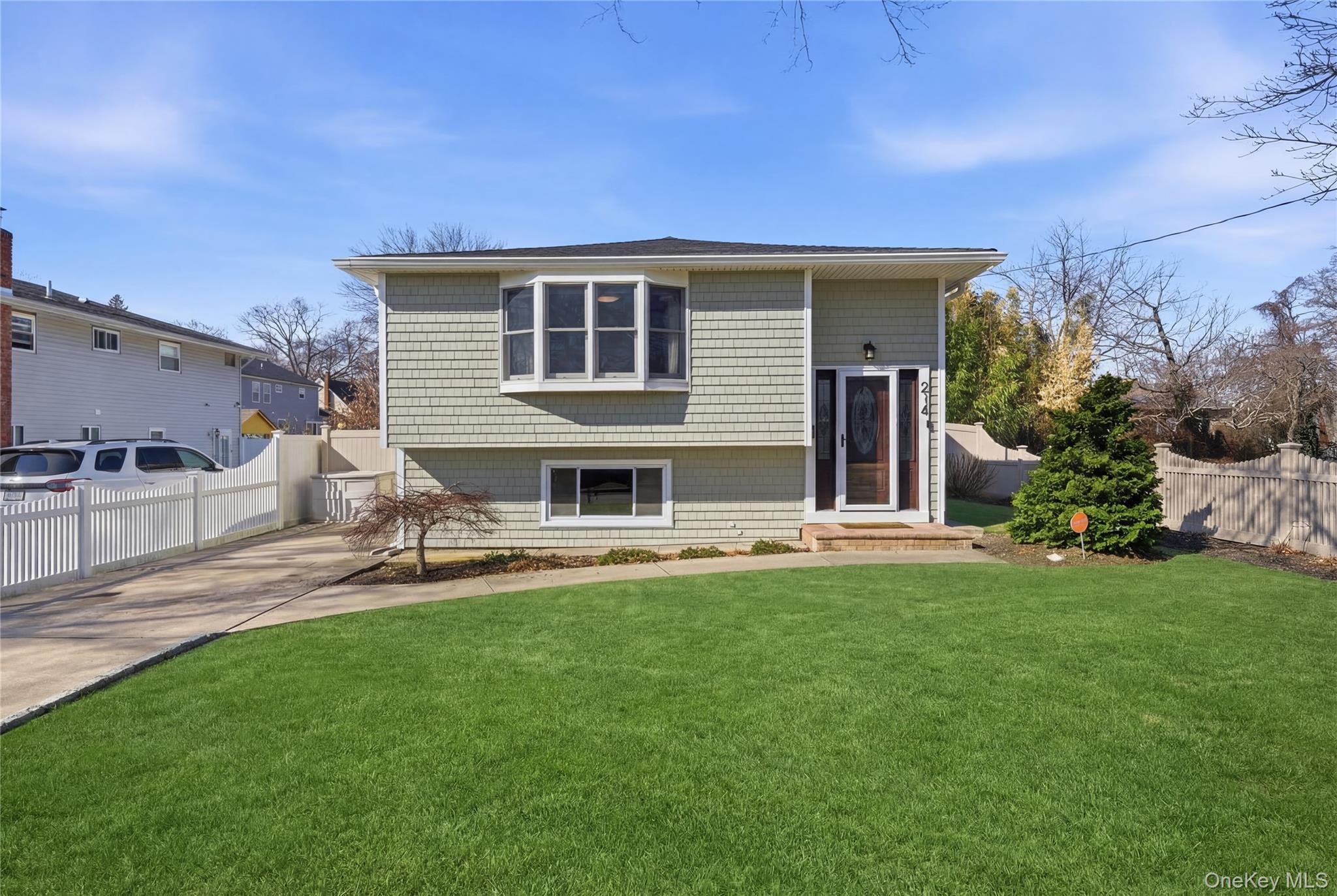 214 Ralph Avenue Babylon, NY 11702 - Photo 3 of 33 a front view of a house with a garden and patio