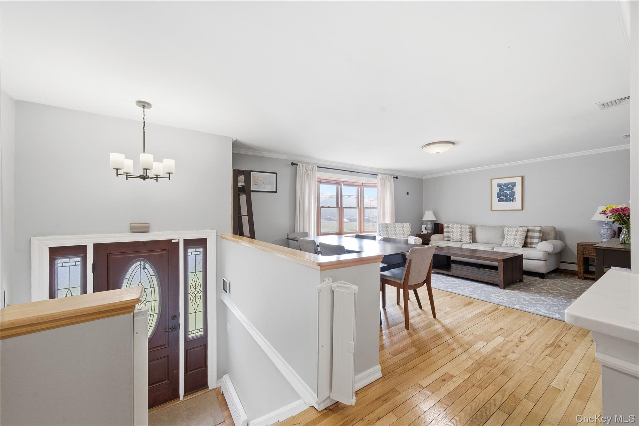 214 Ralph Avenue Babylon, NY 11702 - Photo 4 of 33 a living room with furniture a dining table and a couches with wooden floor