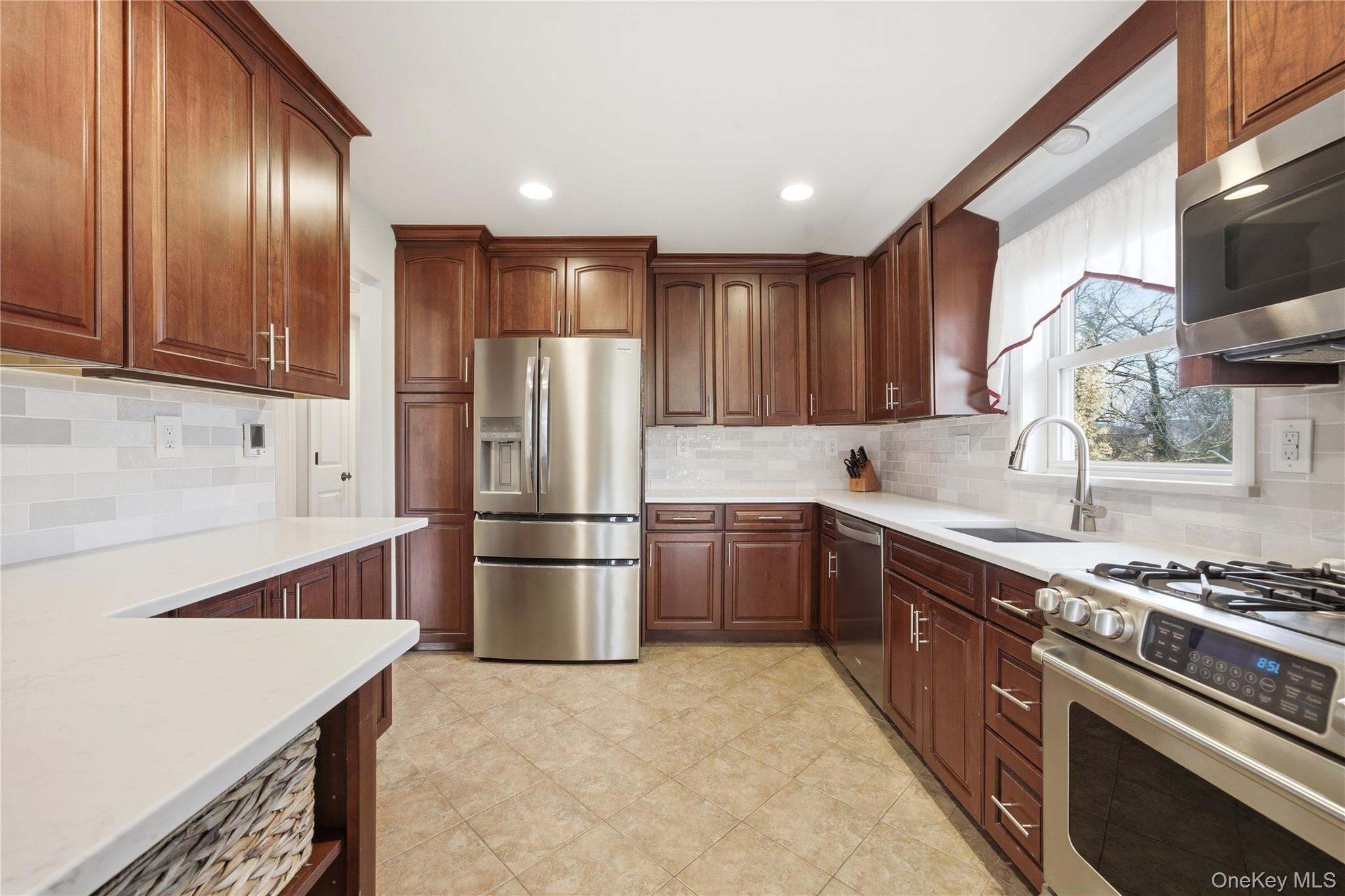 214 Ralph Avenue Babylon, NY 11702 - Photo 7 of 33 a kitchen with stainless steel appliances granite countertop a refrigerator stove and sink