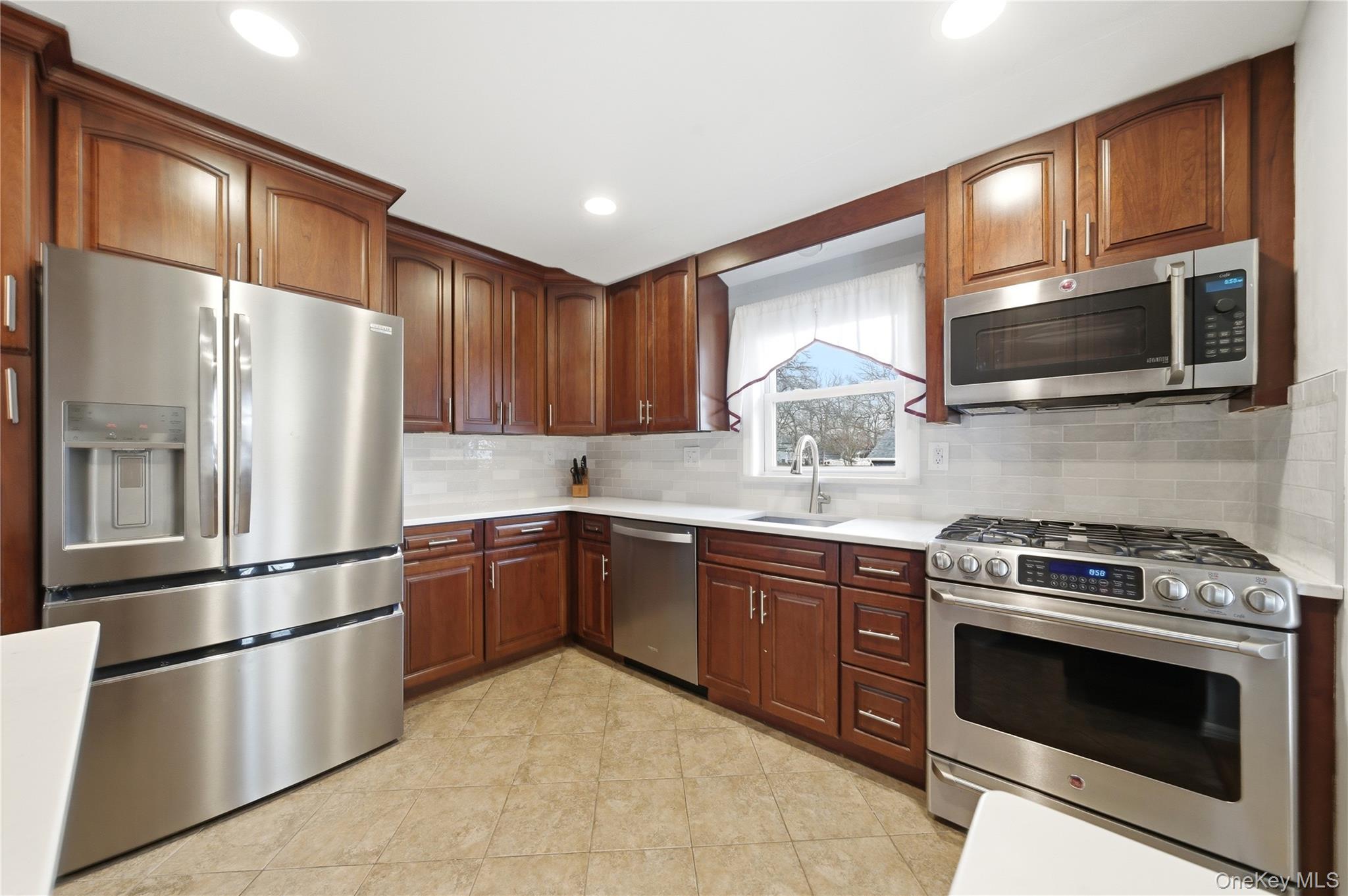 214 Ralph Avenue Babylon, NY 11702 - Photo 9 of 33 a kitchen with stainless steel appliances granite countertop a refrigerator stove a sink dishwasher and microwave