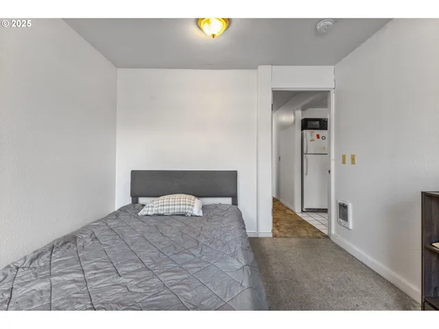 a bedroom with a bed and painting on the wall