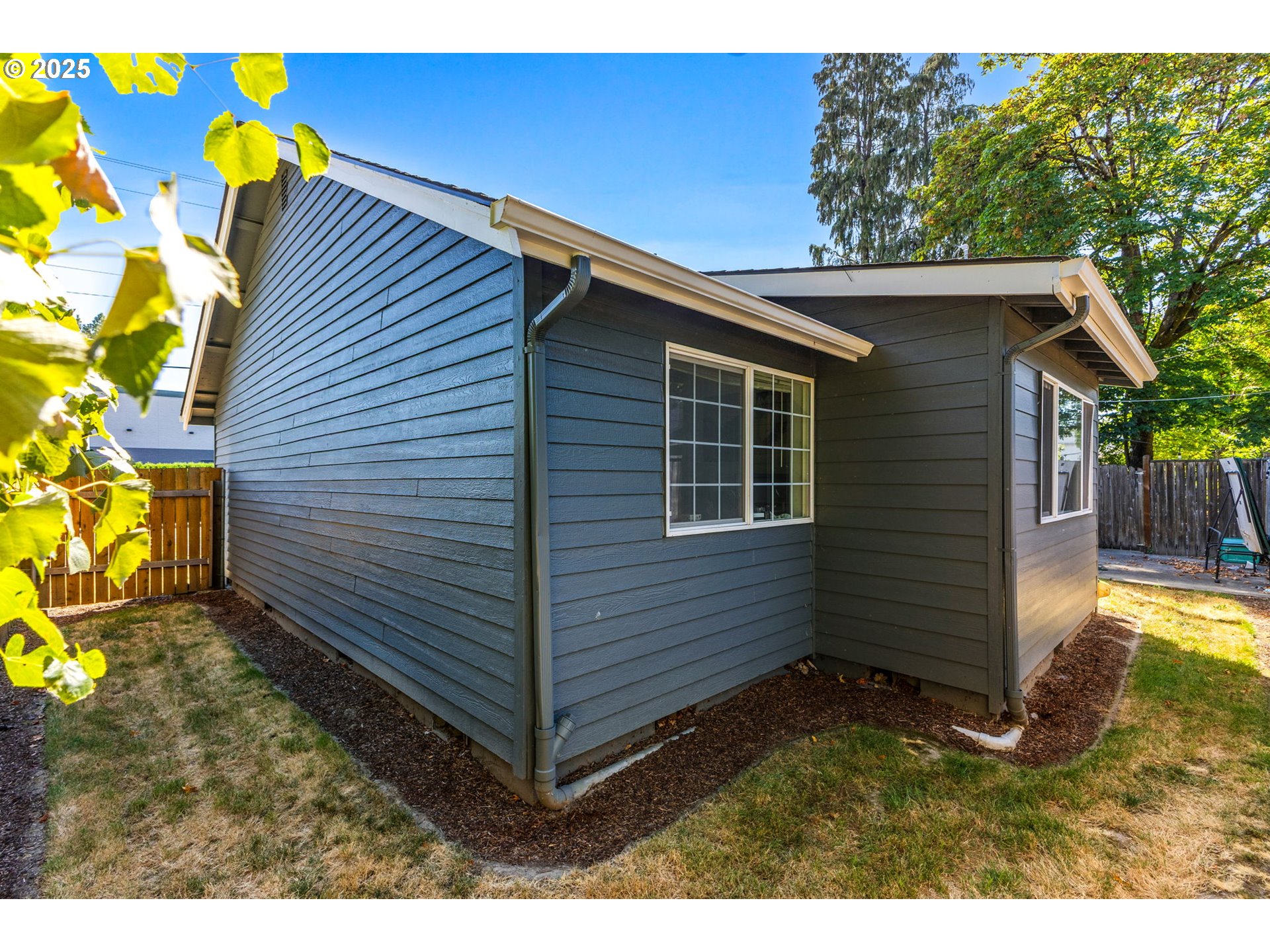1919 Northwest Buchanan Avenue Corvallis, OR 97330 - Photo 5 of 30 a view of a backyard with a large window and potted plants