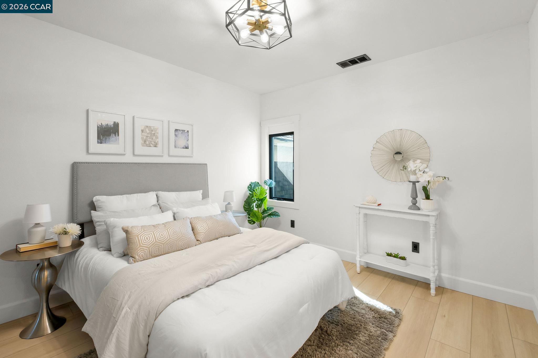 1920 Linden Street Oakland, CA 94607 - Photo 14 of 30 a bedroom with a bed and a chandelier