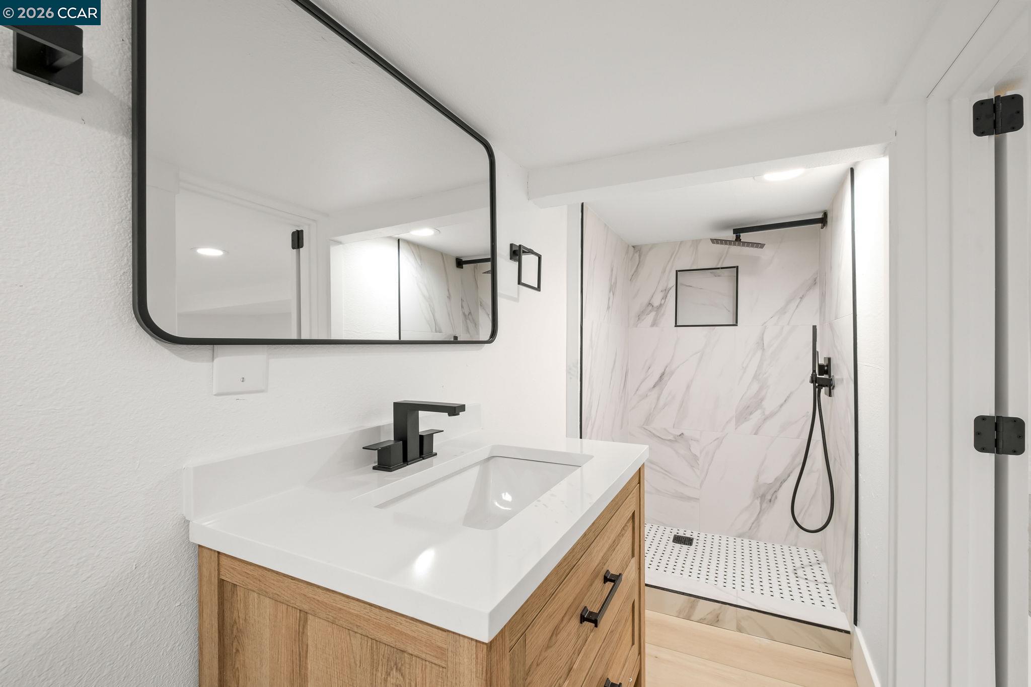 1920 Linden Street Oakland, CA 94607 - Photo 19 of 30 a bathroom with a sink a mirror and shower