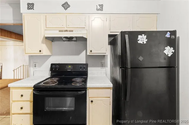 a kitchen with a refrigerator and a stove