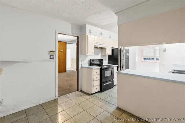 a kitchen with a refrigerator a stove top oven and cabinets