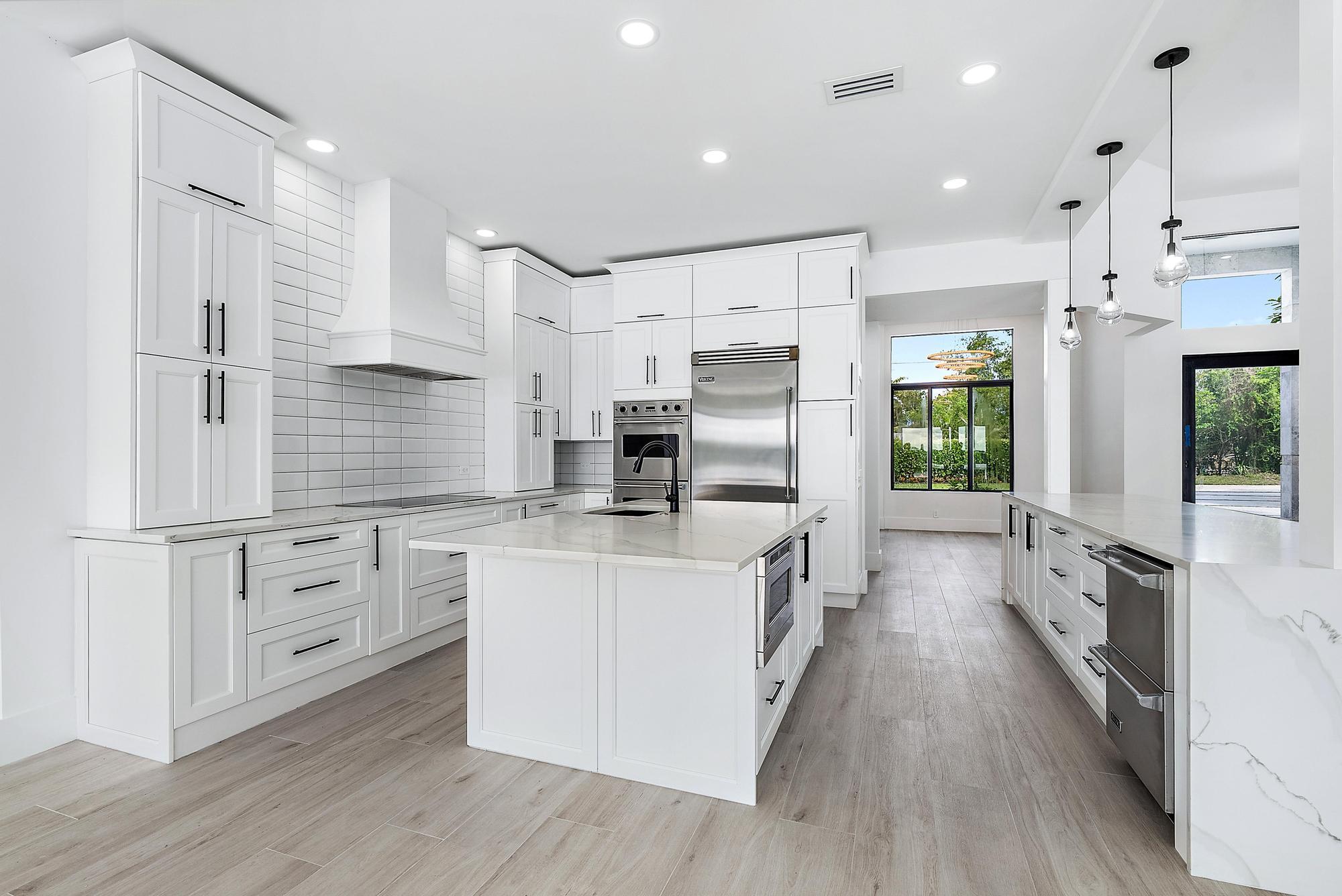 9460 Southeast Point Terrace Jupiter, FL 33469 - Photo 12 of 38 a kitchen with white cabinets and stainless steel appliances