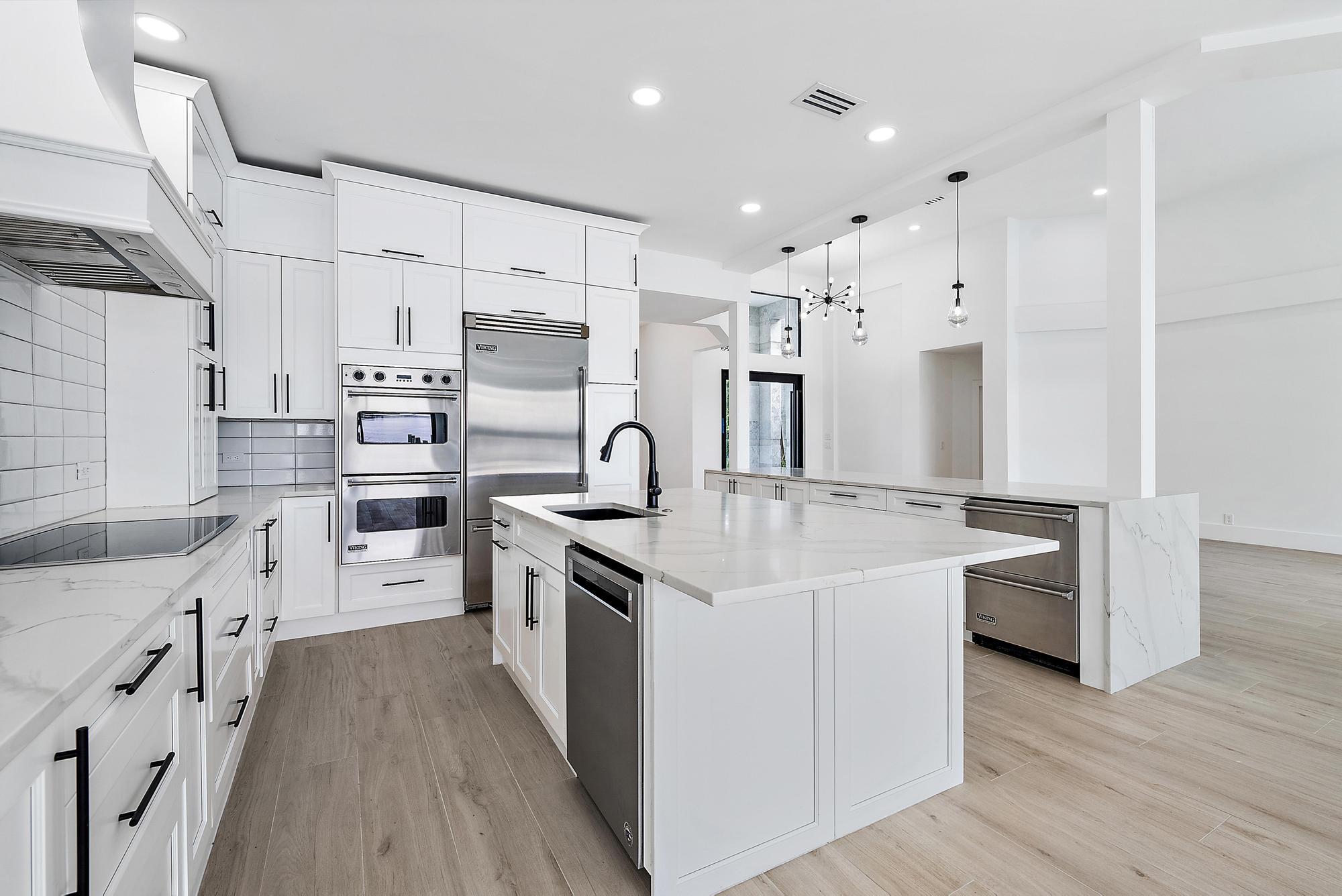 9460 Southeast Point Terrace Jupiter, FL 33469 - Photo 13 of 38 a kitchen with white cabinets and stainless steel appliances