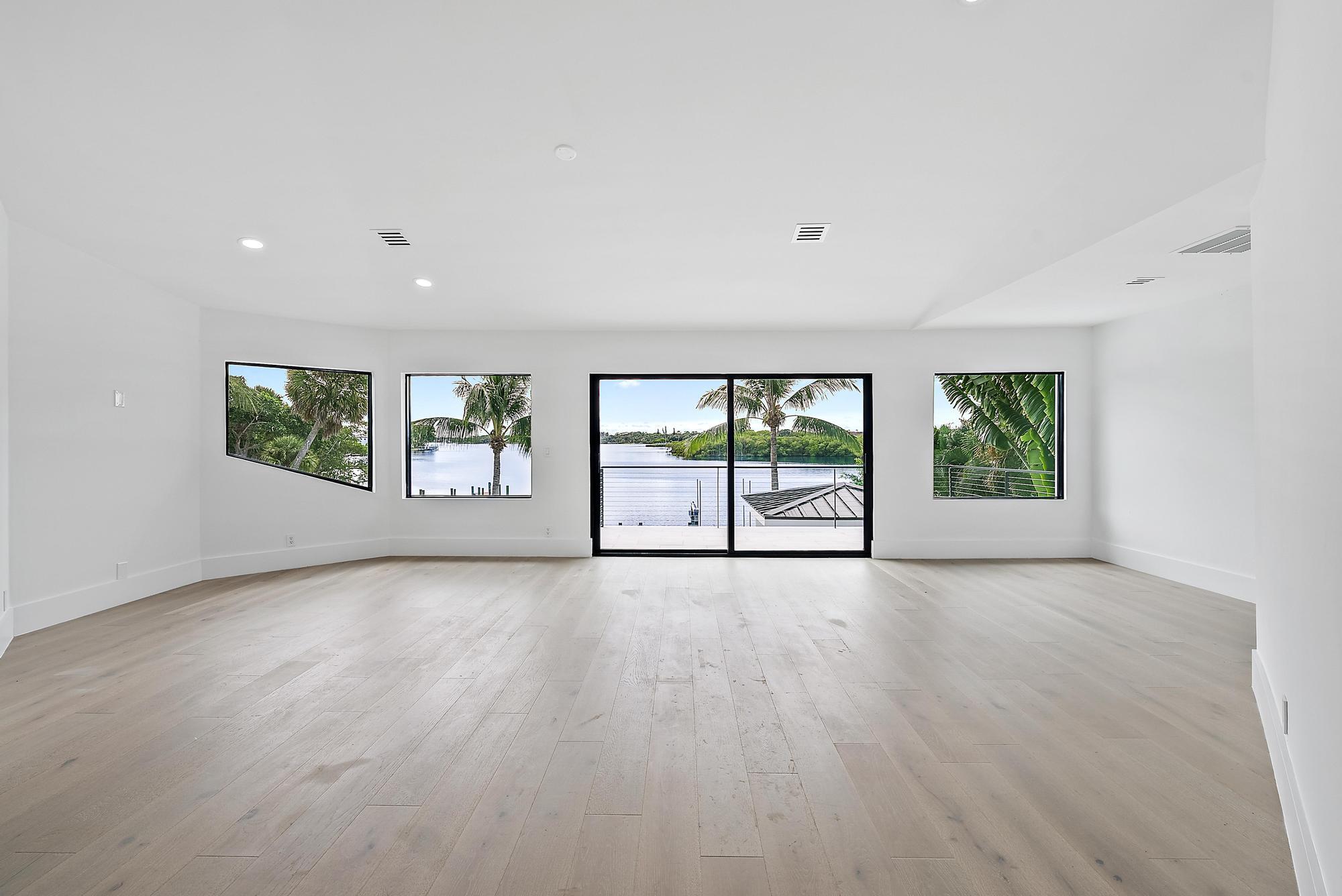 9460 Southeast Point Terrace Jupiter, FL 33469 - Photo 19 of 38 an empty room with wooden floor and windows
