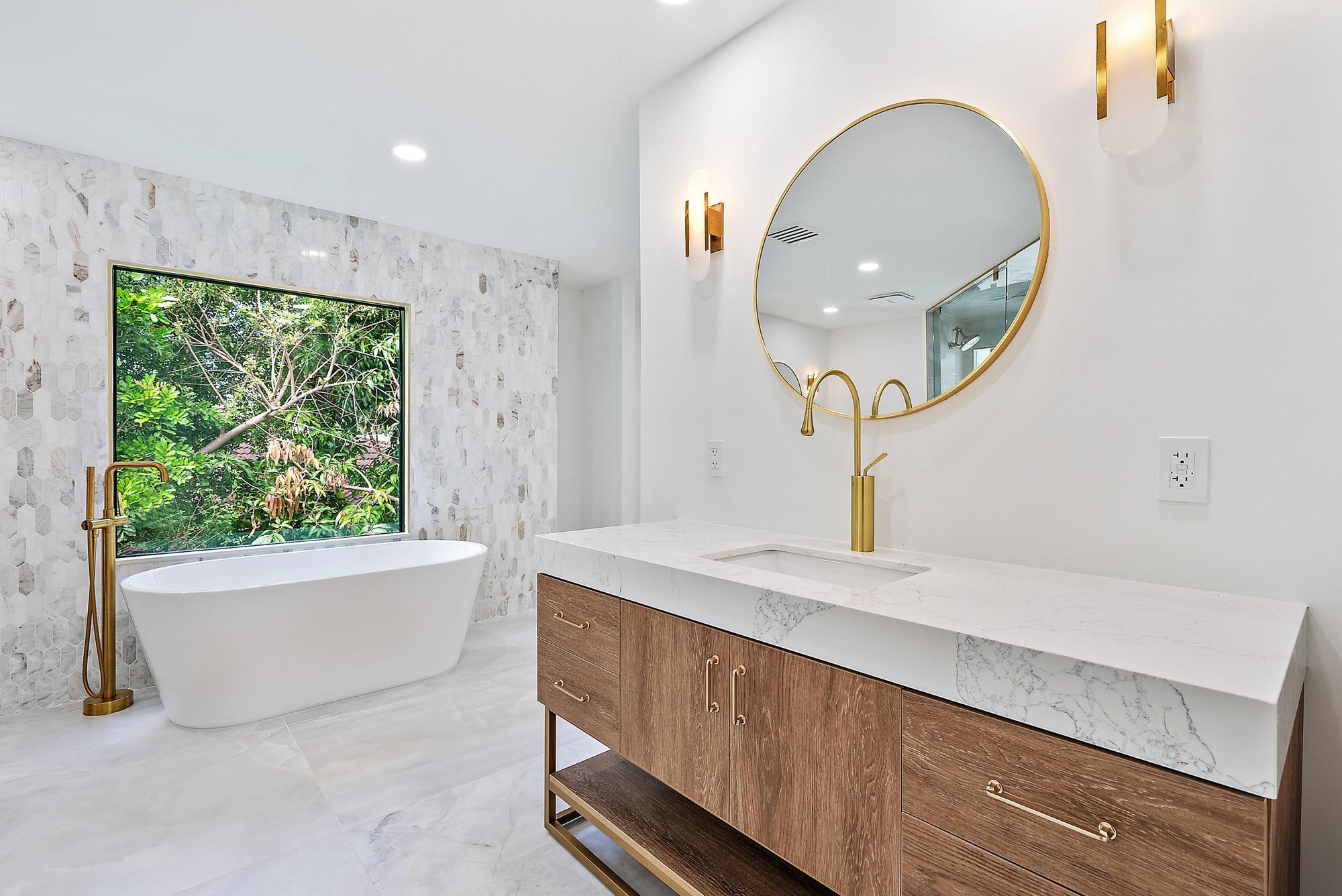 9460 Southeast Point Terrace Jupiter, FL 33469 - Photo 22 of 38 a spacious bathroom with a sink a large mirror and a bathtub