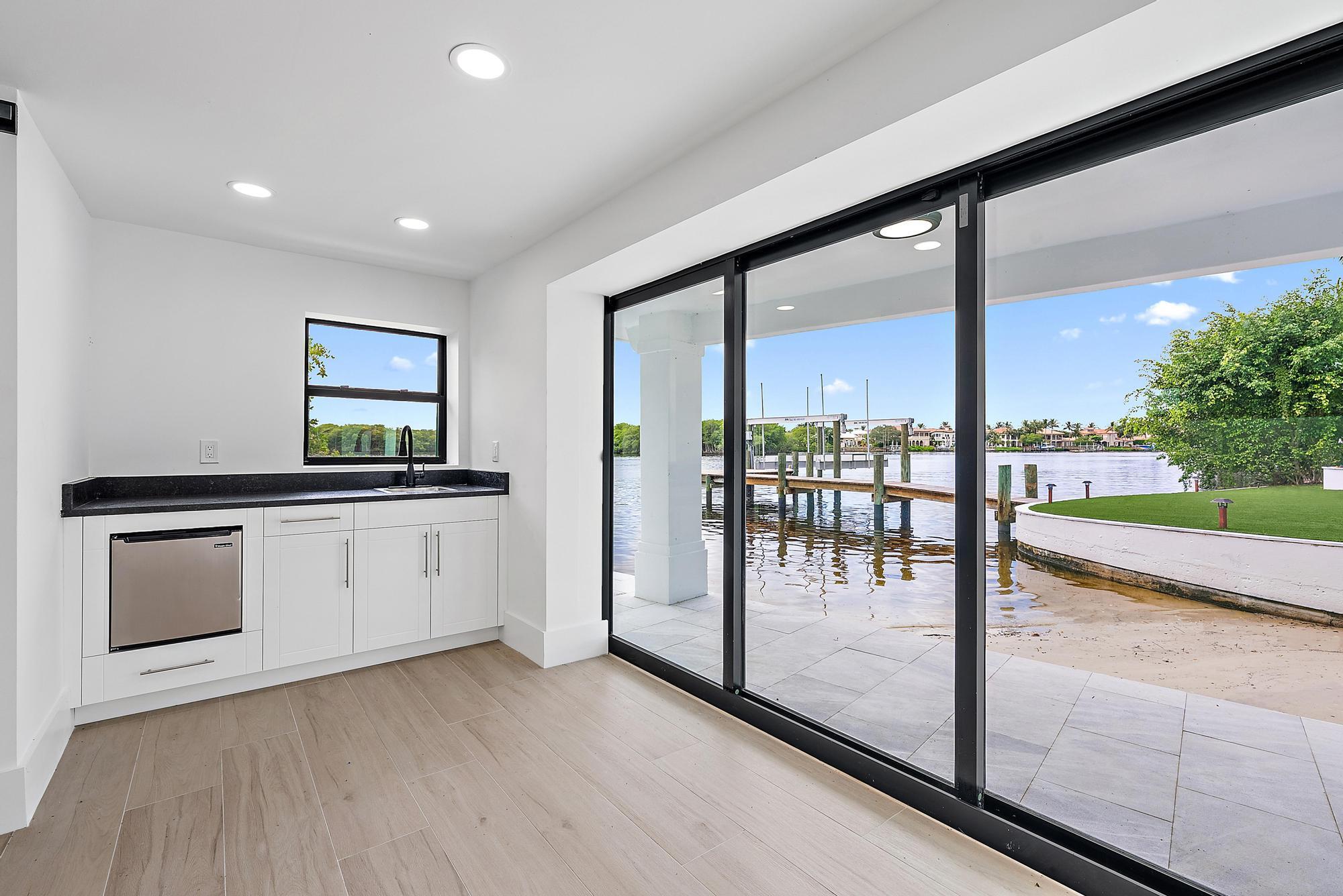 9460 Southeast Point Terrace Jupiter, FL 33469 - Photo 37 of 38 a view of a kitchen with a sink and dishwasher stove top oven with a large window