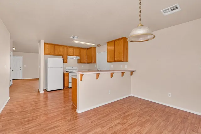 a view of kitchen with wooden floor and electronic appliances