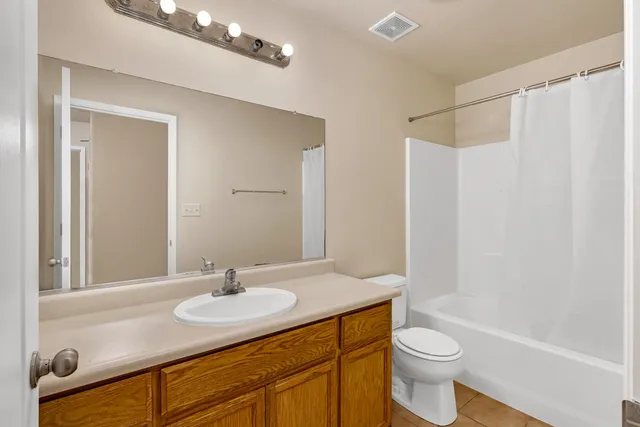 a bathroom with a granite countertop sink a toilet and shower