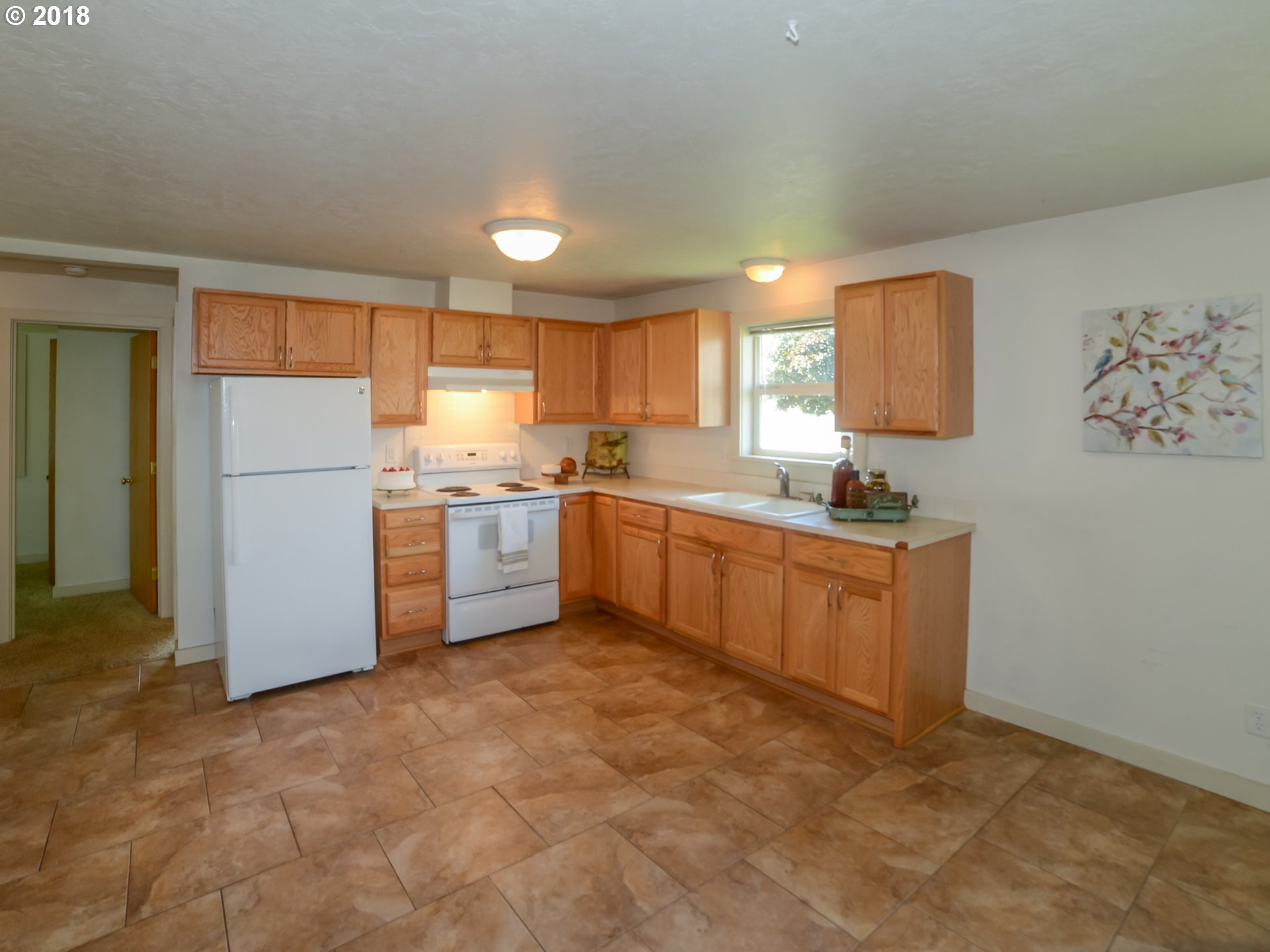 1009 L Street Springfield, OR 97477 - Photo 3 of 5 a kitchen with a refrigerator a stove top oven a sink and a window