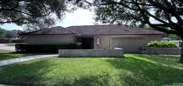 a front view of a house with a garden and plants