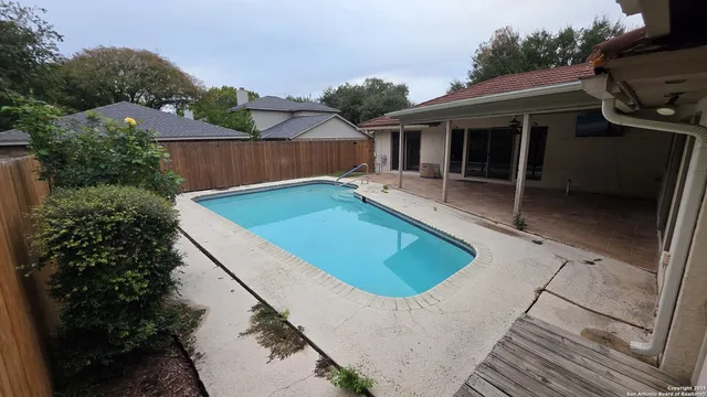 a view of house with swimming pool and porch