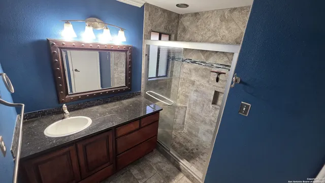 a bathroom with a sink vanity granite and a mirror