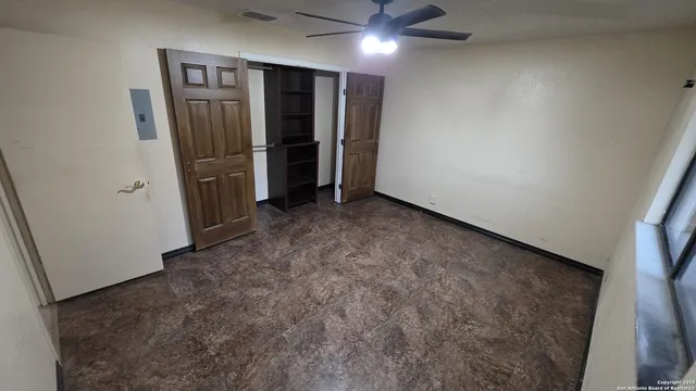 an empty room with closet and windows