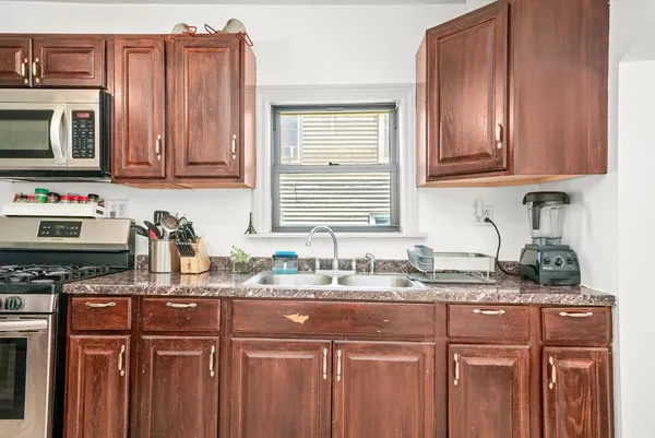 a kitchen with stainless steel appliances granite countertop a sink stove and cabinets