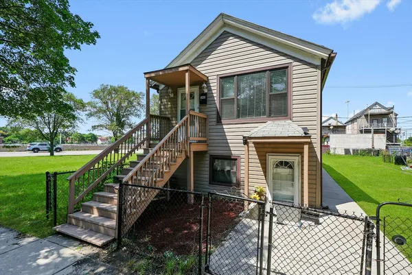 a front view of house along with deck and outdoor seating