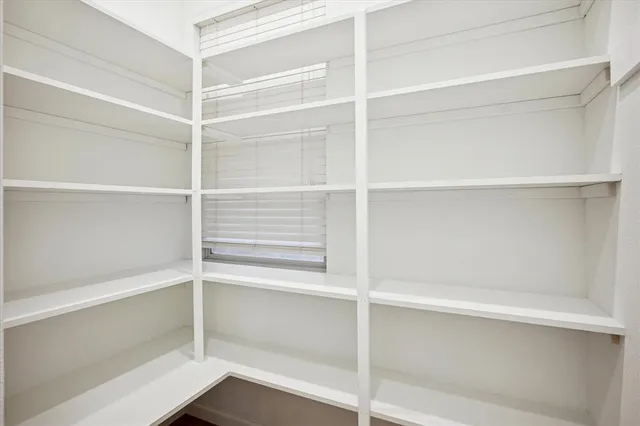 a view of walk in closet with empty racks