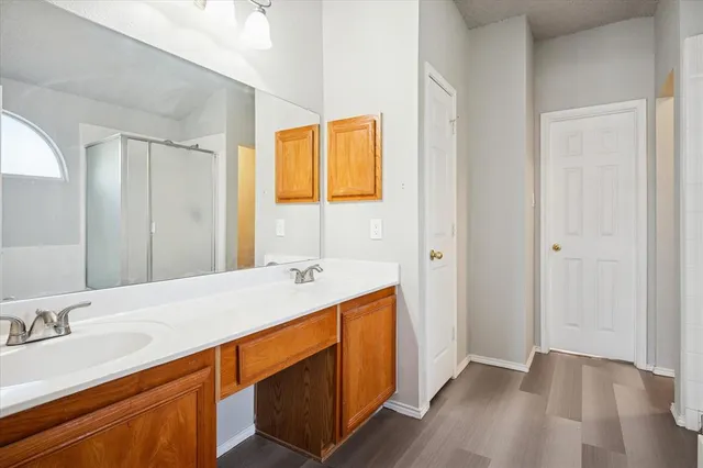 a en suite bathroom with a granite countertop sink and a mirror