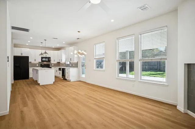 a view of an empty room with kitchen appliances and a window