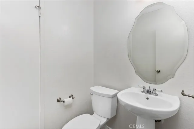 a bathroom with a sink and mirror with toilet