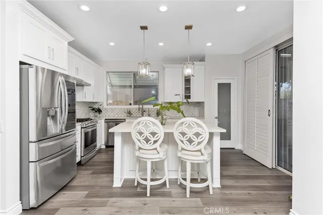 a kitchen with granite countertop a refrigerator and wooden floor