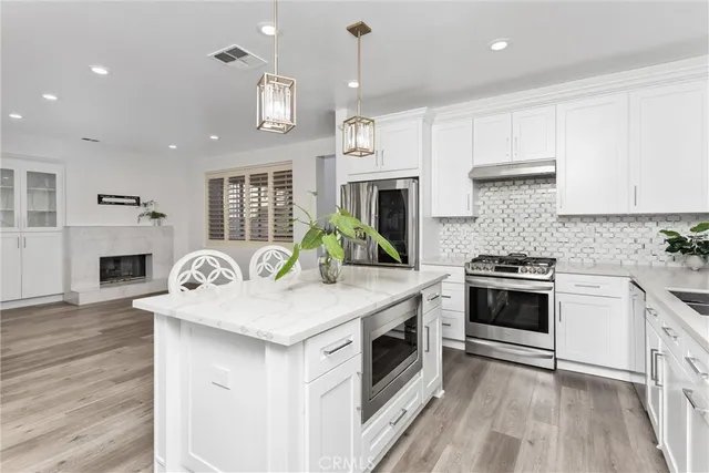 a kitchen with a stove a sink a microwave a refrigerator and cabinets