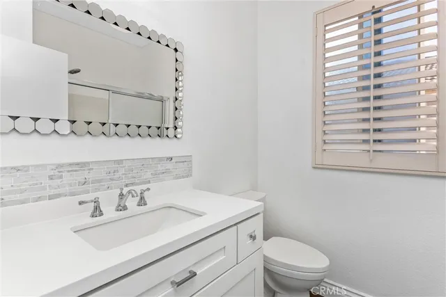 a bathroom with a sink a toilet and mirror
