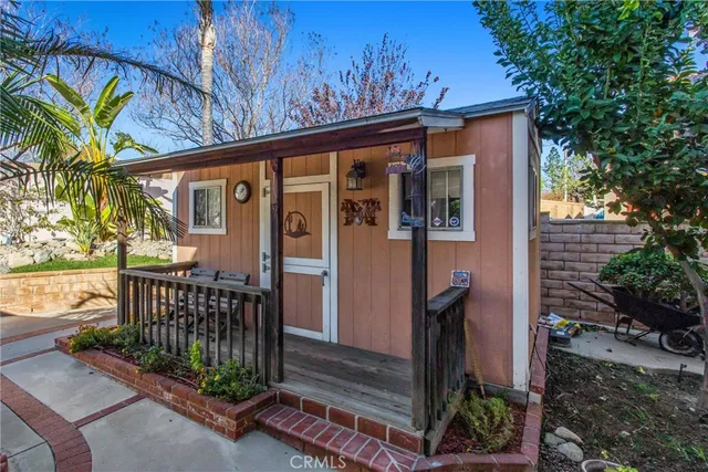 a view of a house with a small yard and floor to ceiling window and wooden fence
