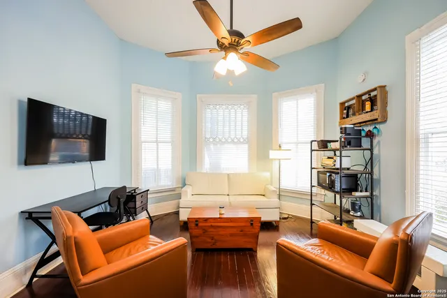 a living room with furniture a flat screen tv and a window